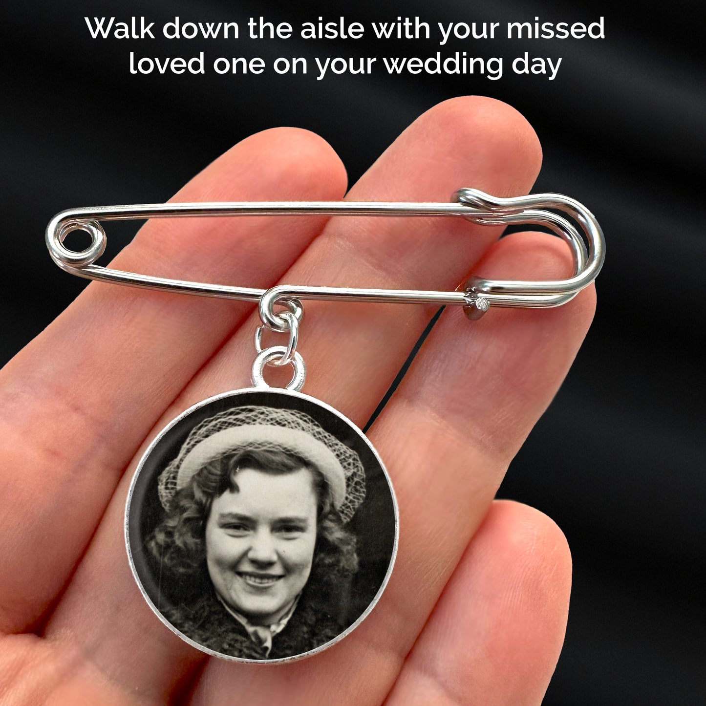 A photo pin for memorial at a wedding. It is a circle shown in the palm of a hand. The text reads walk down the aisle with your missed loved one on your wedding day. The wedding memorial pin is a silver circle with a safety pin style top.