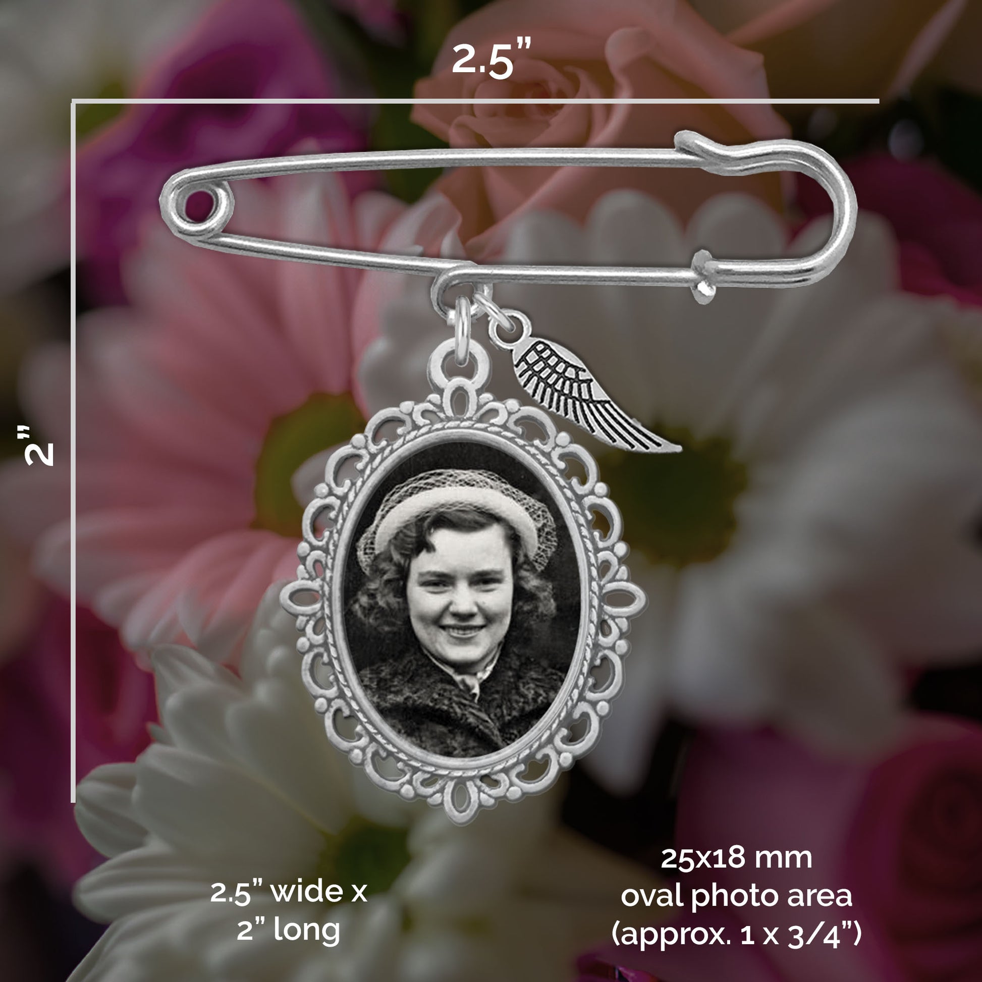 Silver-toned metal photo wedding pin with an oval photo frame and small wing charm, shown over a blurred floral background with measurement annotations indicating 2.5 inches wide by 2 inches long.