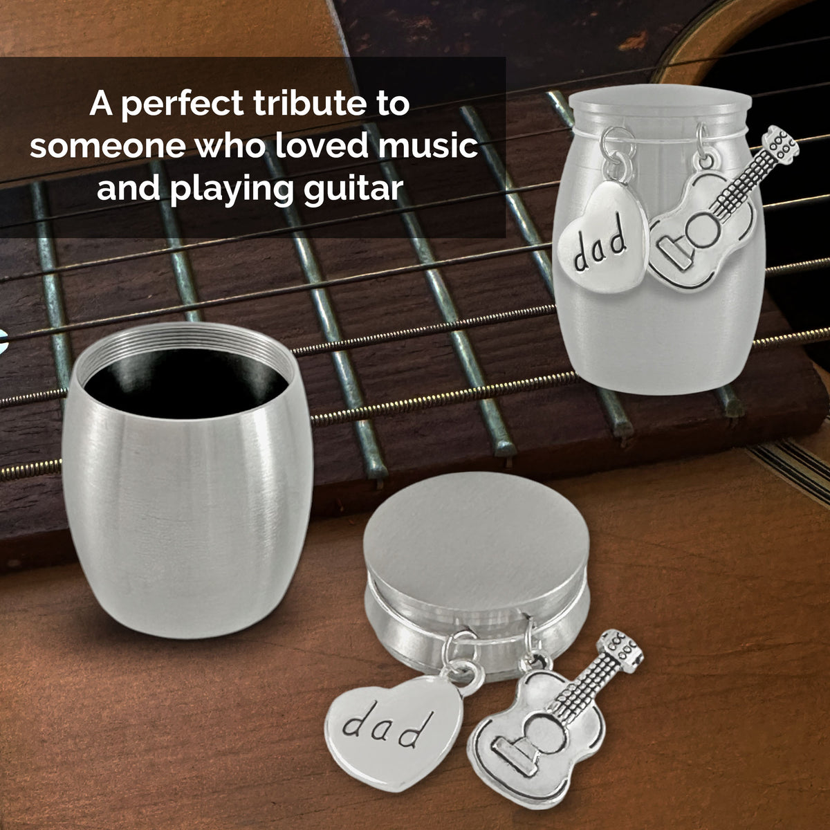 Brushed silver small stainless steel urns shown open on a dark textured background, with the open round container on the left and the round lid on the right. A heart-shaped charm engraved with 'dad' and a guitar-shaped charm hang from the top. Both urns shown over a picture of a guitar with the text "A perfect tribute to someone who loved music and playing guitar"