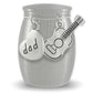 A brushed silver small stainless steel urn shown on a white background, A heart-shaped charm engraved with 'dad' and a guitar-shaped charm hang from the top.