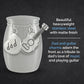 A stainless steel small urn jar with hanging stainless steel charms shaped like a guitar and a heart engraved with the word 'dad,' shown on a dark textured background with descriptive text.