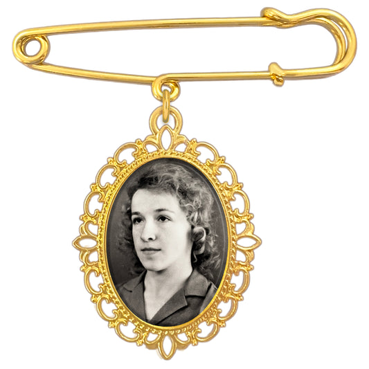 A gold wedding bouquet photo charm pin featuring an ornate oval frame with a black-and-white portrait photo insert, shown on a plain white background.