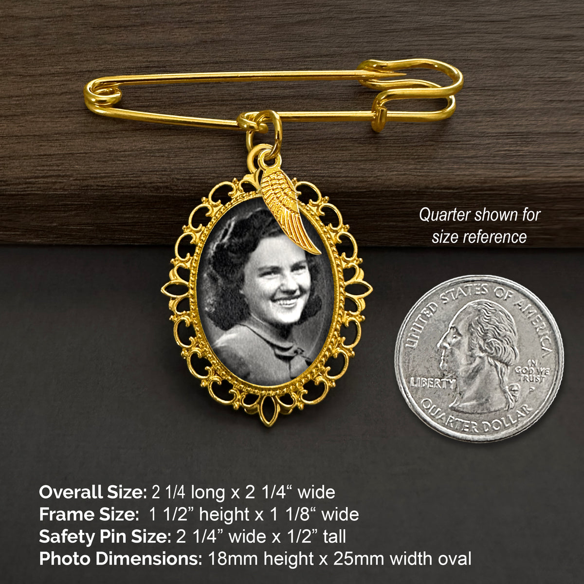 Gold wedding bouquet photo charm pin with angel wing charm and ornate oval frame holding a black-and-white photo portrait, shown on a dark wood and dark gray background with a quarter for size reference and printed dimensions.