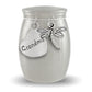 A silver cremation urn shaped like a small jar with a lid, featuring a heart-shaped tag engraved with 'Grandma' and a dragonfly charm, shown on a white background.