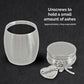 A brushed silver metal miniature size cremation urn with a heart-shaped charm engraved 'Grandma' and a dragonfly charm, shown with the lid unscrewed on a dark textured background with instructional text.