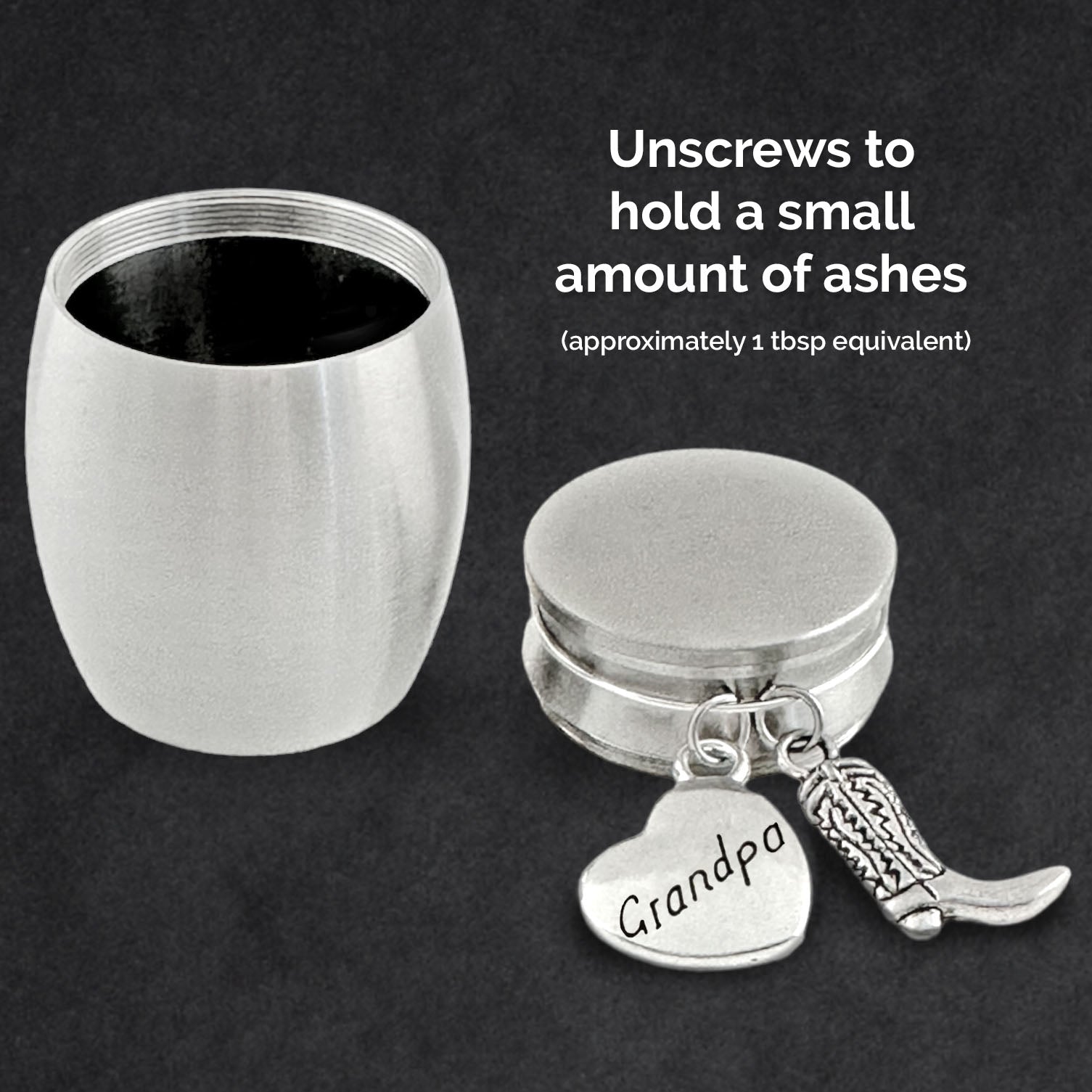 A silver cremation urn shown unscrewed on a dark background, with the lid laying on the left and the main urn compartment with an attached heart-shaped 'Grandpa' pendant and cowboy boot charm on the right. White text explains how to unscrew the tin to hold ashes and that it holds a small amount of ashes.