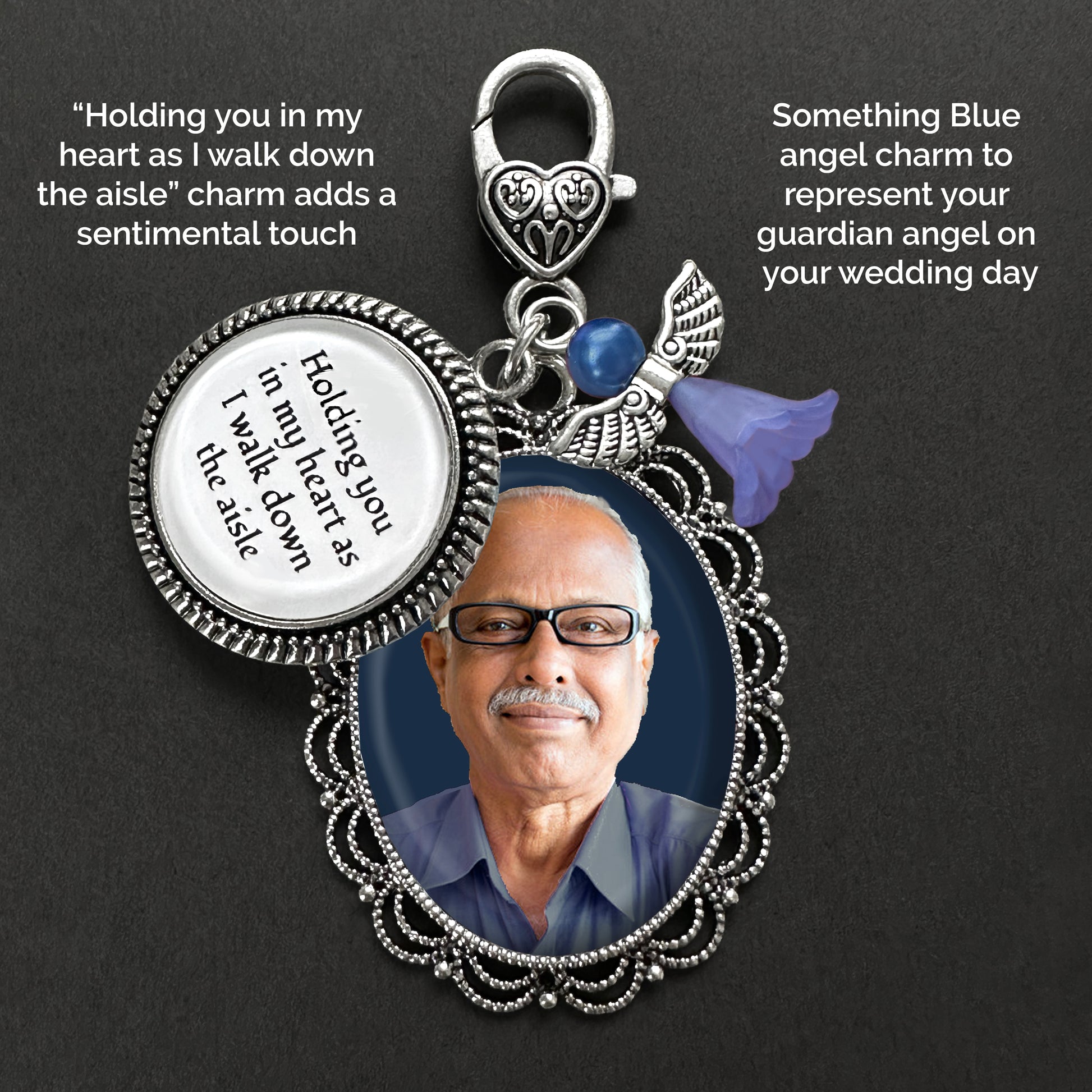Silver-toned pendant with an oval photo frame charm, a round charm reading 'Holding you in my heart as I walk down the aisle,' a small blue angel charm, shown on a dark background with text.