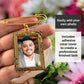 Gold photo frame with a man's portrait held by a hand against a floral background
